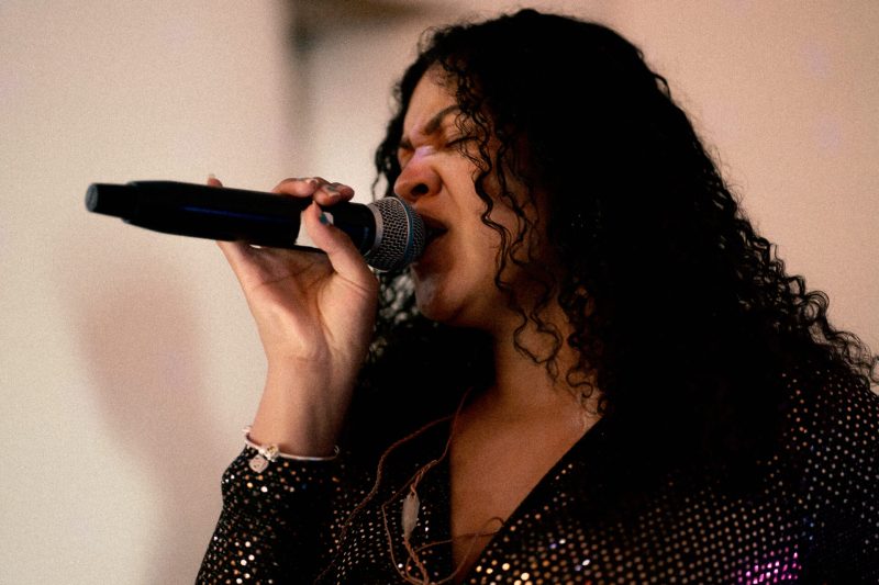 Female singer performing passionately into a microphone.