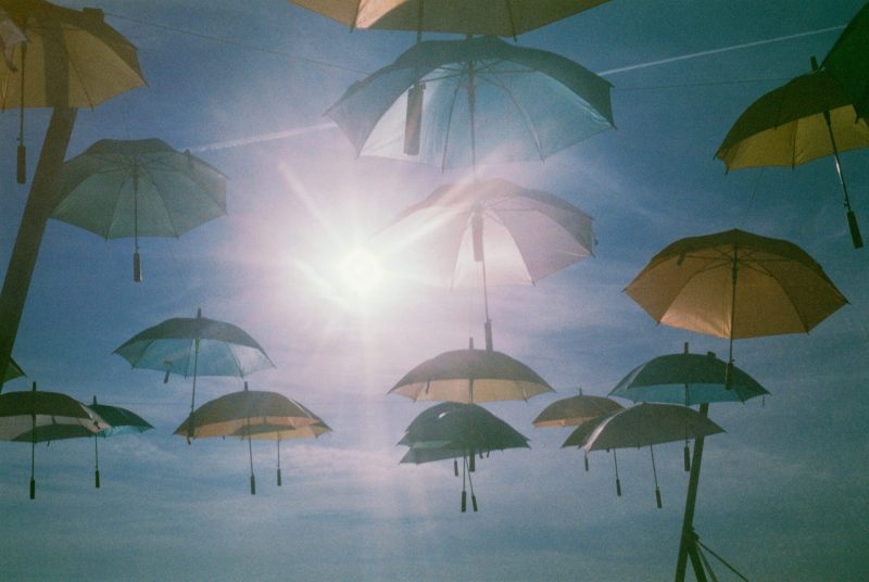Umbrellas suspended against a sunny sky creating an artistic canopy for a wedding.