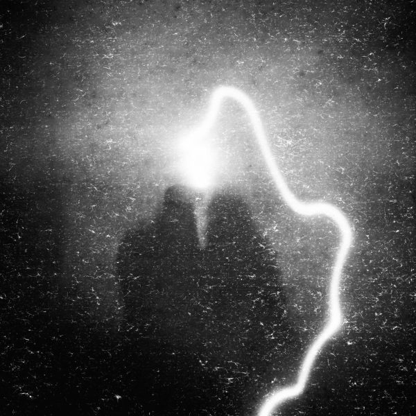 A monochrome image capturing a light streak against a dark, textured background in a magic mirror.