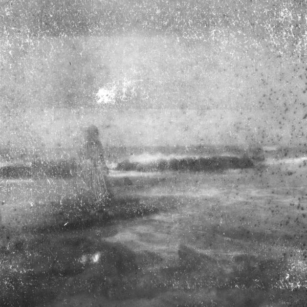 A person walks on a beach in hazy, overcast conditions, with the scene captured in a grainy black and white photograph, reminiscent of a moment frozen by a magic mirror.